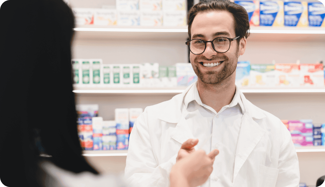 Apotheker lächelt Kundin an